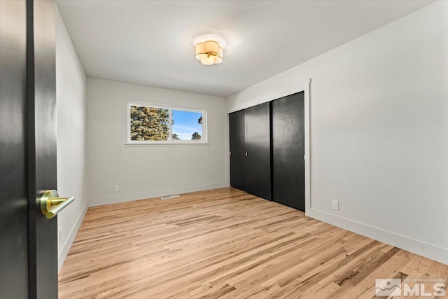 bedroom with light wood-type flooring and a closet