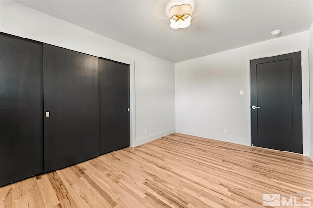 unfurnished bedroom with a closet and light hardwood / wood-style flooring