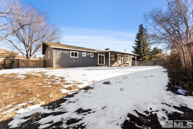 view of snow covered rear of property