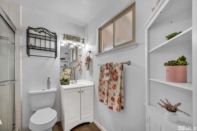 bathroom with hardwood / wood-style flooring, vanity, walk in shower, and toilet