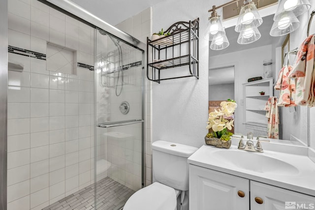 bathroom featuring vanity, an enclosed shower, and toilet