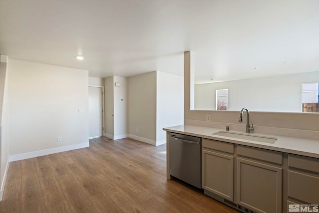 kitchen featuring light wood-type flooring, dishwasher, sink, and gray cabinetry