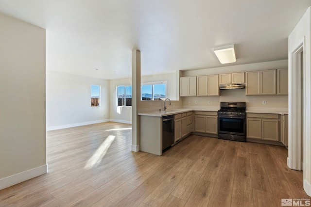 kitchen featuring stainless steel gas range oven, black dishwasher, sink, and light hardwood / wood-style floors