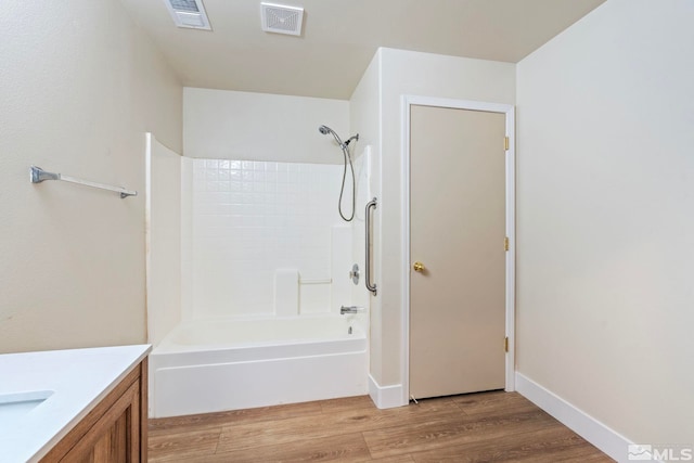 bathroom featuring vanity, hardwood / wood-style flooring, and bathtub / shower combination