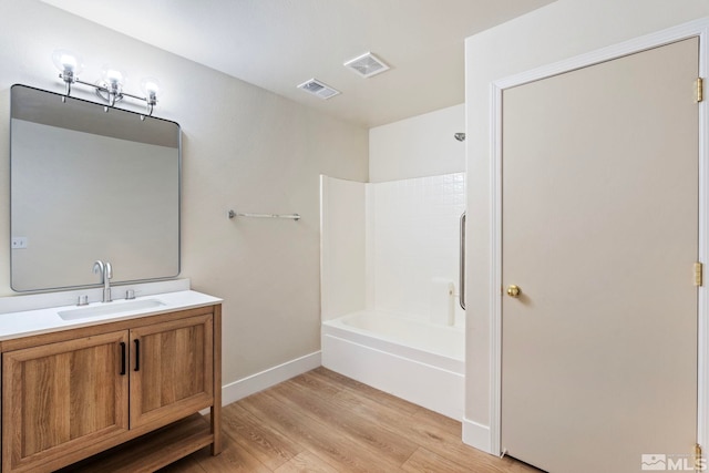 bathroom featuring shower / washtub combination, hardwood / wood-style floors, and vanity