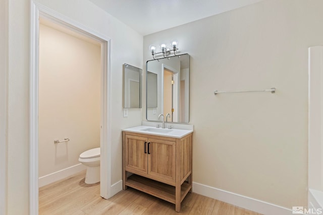 bathroom featuring vanity, hardwood / wood-style floors, and toilet