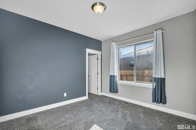 empty room featuring baseboards and carpet floors