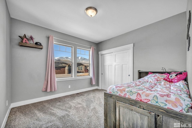 bedroom featuring a closet, carpet flooring, visible vents, and baseboards