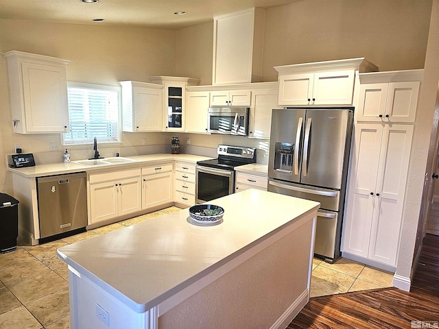 kitchen featuring white cabinetry, sink, a center island, and appliances with stainless steel finishes