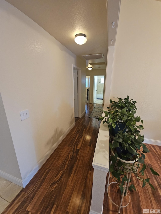 corridor with dark wood-type flooring and a textured ceiling