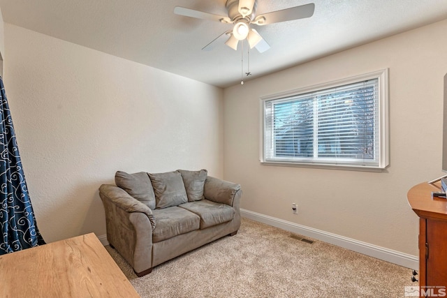 carpeted living room with ceiling fan