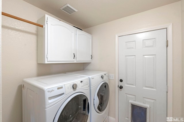 clothes washing area featuring cabinets and washing machine and dryer