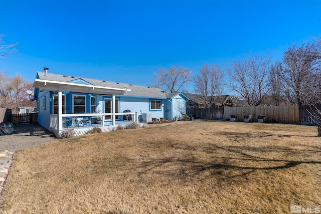 rear view of property featuring a sunroom and a yard