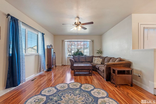 living room featuring ceiling fan, light hardwood / wood-style floors, and a wealth of natural light