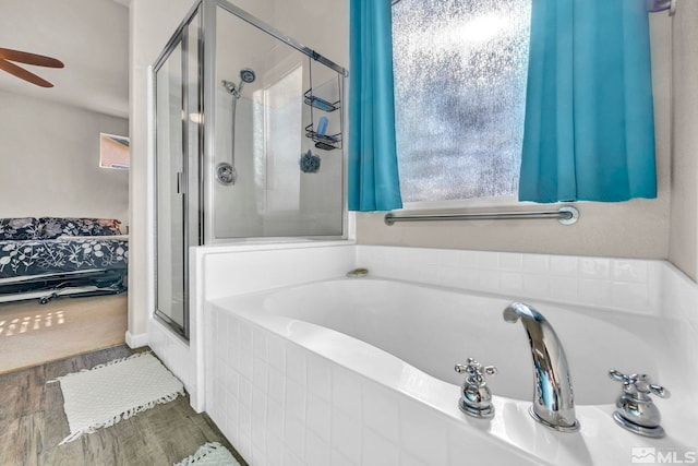 bathroom featuring shower with separate bathtub, hardwood / wood-style floors, and ceiling fan