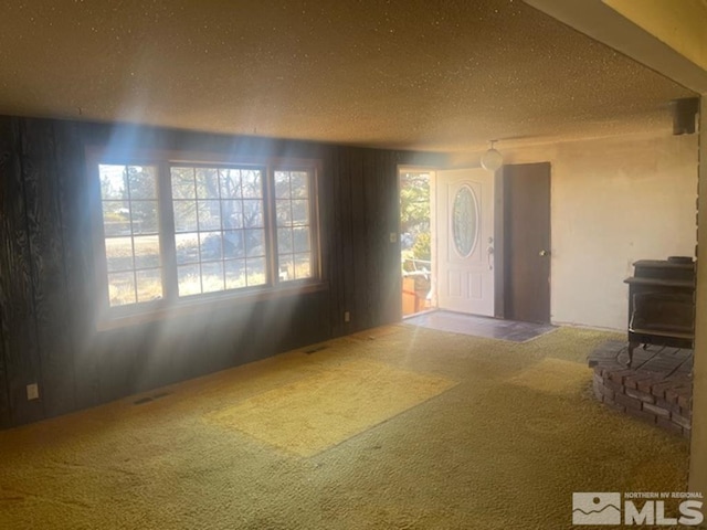 carpeted entryway featuring a textured ceiling