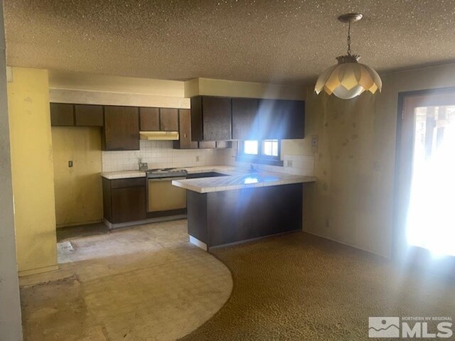 kitchen with dark brown cabinets, decorative light fixtures, decorative backsplash, and kitchen peninsula