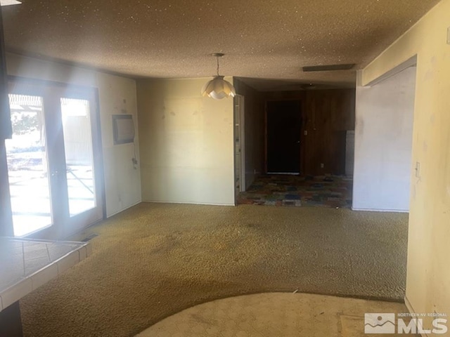 carpeted empty room featuring a textured ceiling