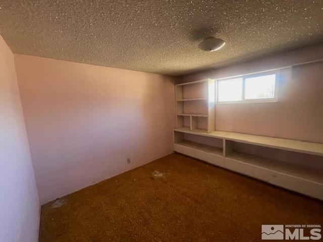 carpeted spare room featuring a textured ceiling