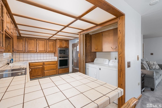 kitchen with washer and clothes dryer, decorative backsplash, tile countertops, and stainless steel appliances