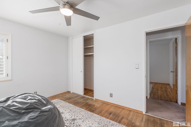 bedroom featuring hardwood / wood-style flooring, ceiling fan, and a closet