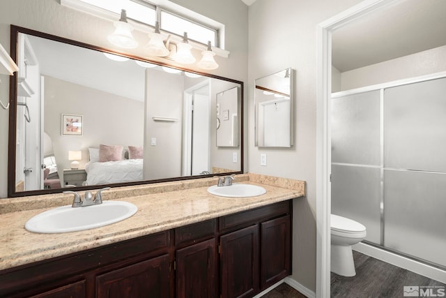 bathroom featuring an enclosed shower, vanity, hardwood / wood-style flooring, and toilet