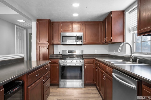 kitchen with stainless steel appliances, light hardwood / wood-style floors, and sink