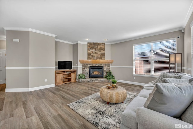 living room with ornamental molding, a stone fireplace, and hardwood / wood-style floors