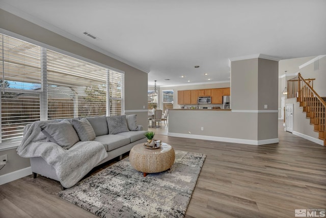 living room featuring ornamental molding and light hardwood / wood-style flooring