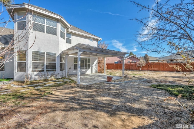 back of property with a pergola and a patio area