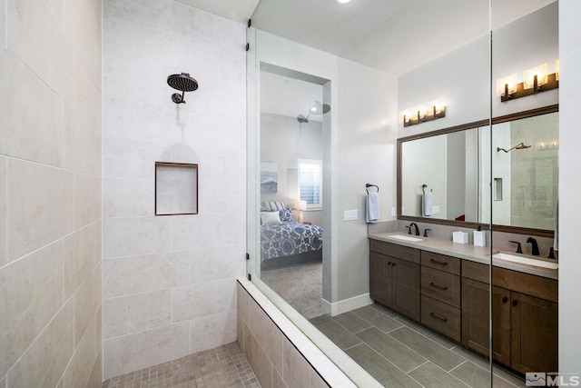 bathroom with a tile shower, vanity, and tile patterned floors