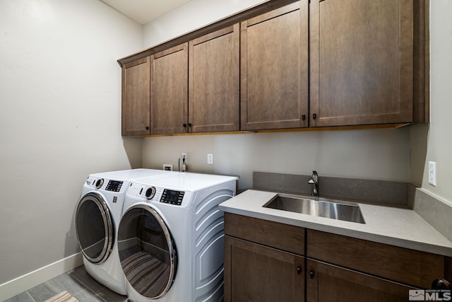 laundry room featuring cabinets, sink, and independent washer and dryer