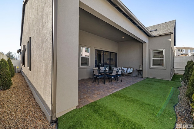 rear view of house featuring a patio area and a lawn