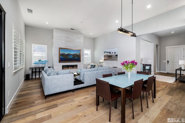 dining space featuring a fireplace and light hardwood / wood-style flooring