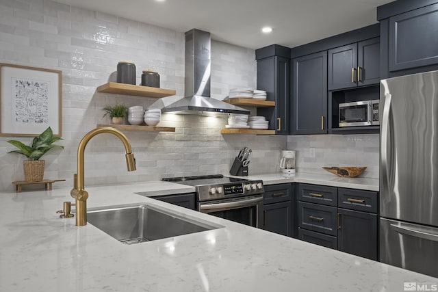 kitchen with wall chimney exhaust hood, sink, tasteful backsplash, appliances with stainless steel finishes, and light stone countertops