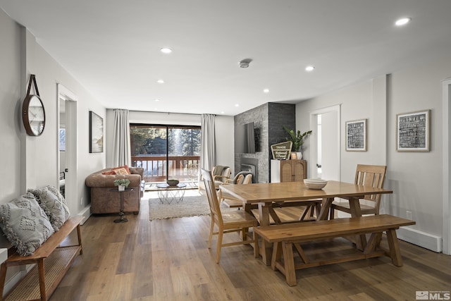 dining room with hardwood / wood-style flooring and a fireplace