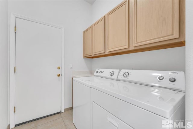 laundry room with cabinets, washer and dryer, and light tile patterned floors