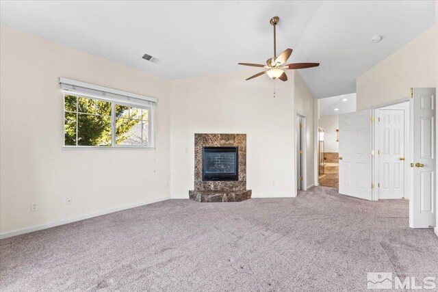 unfurnished living room featuring lofted ceiling, a fireplace, ceiling fan, and carpet flooring