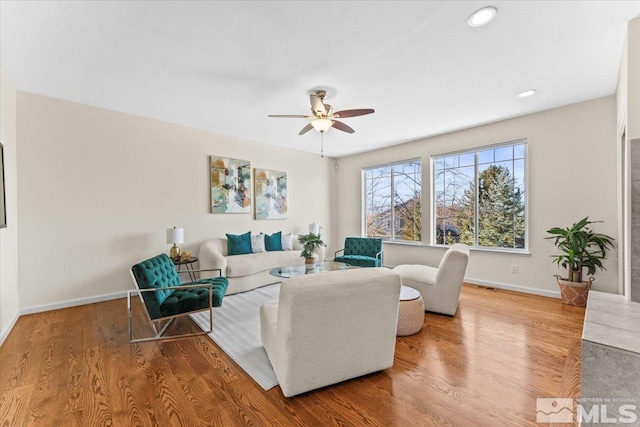 living room featuring hardwood / wood-style flooring and ceiling fan