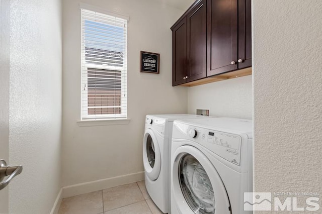 laundry area with independent washer and dryer, cabinets, and light tile patterned floors