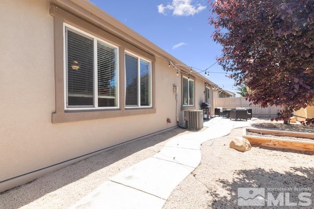 view of side of home with cooling unit and a patio area