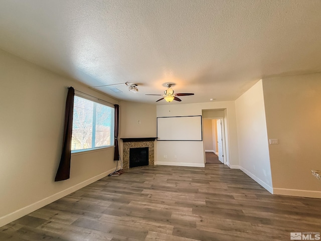 unfurnished living room with wood-type flooring, ceiling fan, and a textured ceiling