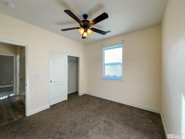 unfurnished bedroom featuring dark carpet, a closet, and ceiling fan