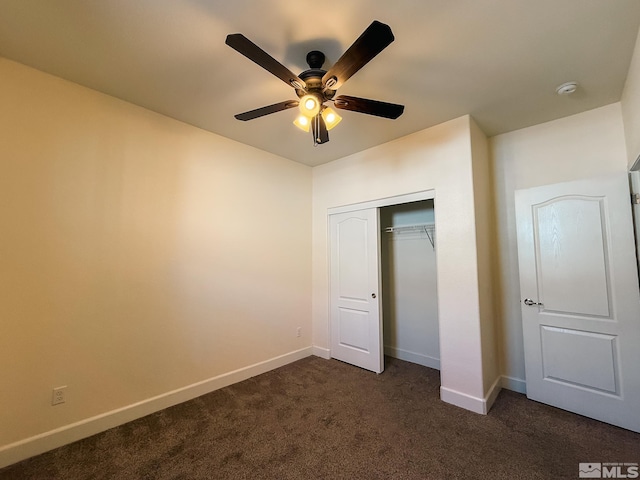 unfurnished bedroom featuring ceiling fan, dark carpet, and a closet