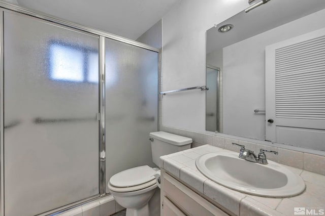 bathroom with vanity, a shower with shower door, and toilet