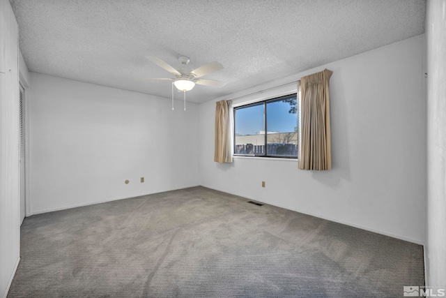 carpeted empty room featuring ceiling fan and a textured ceiling