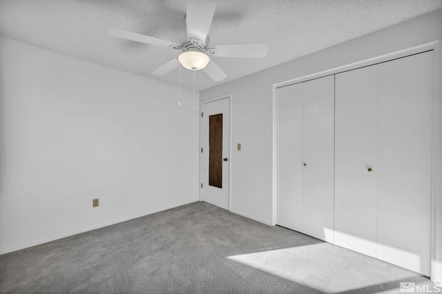 unfurnished bedroom featuring ceiling fan, carpet floors, a closet, and a textured ceiling