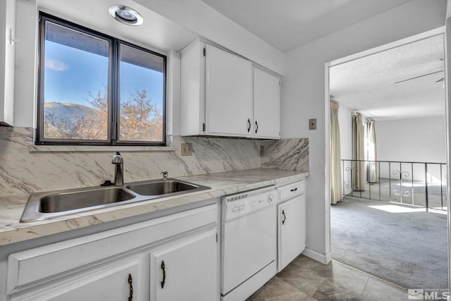 kitchen with sink, white cabinetry, white dishwasher, light colored carpet, and decorative backsplash