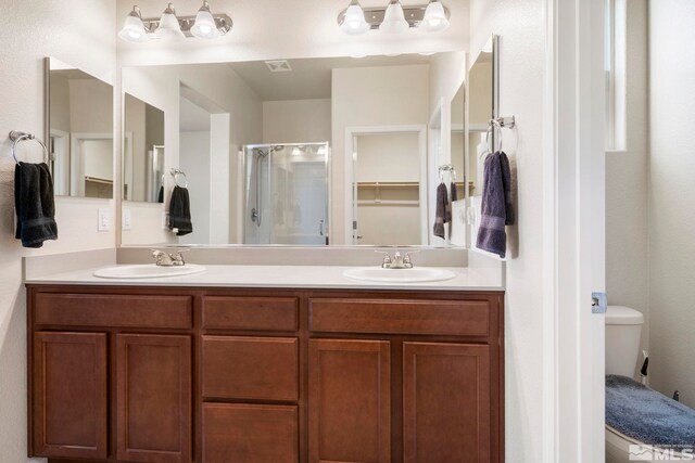 bathroom with vanity, an enclosed shower, and toilet