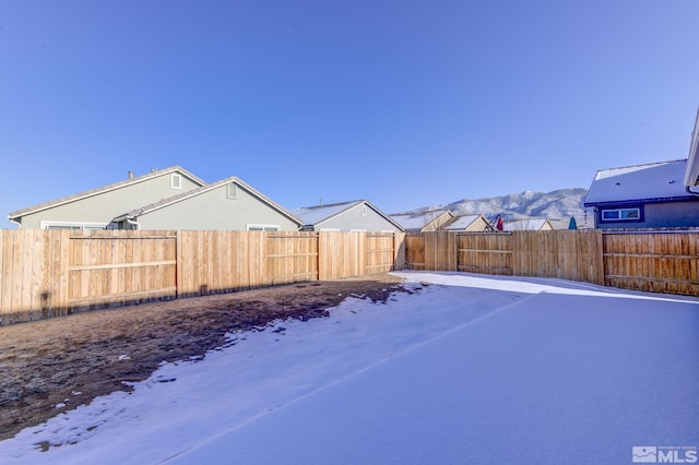 yard covered in snow featuring a mountain view